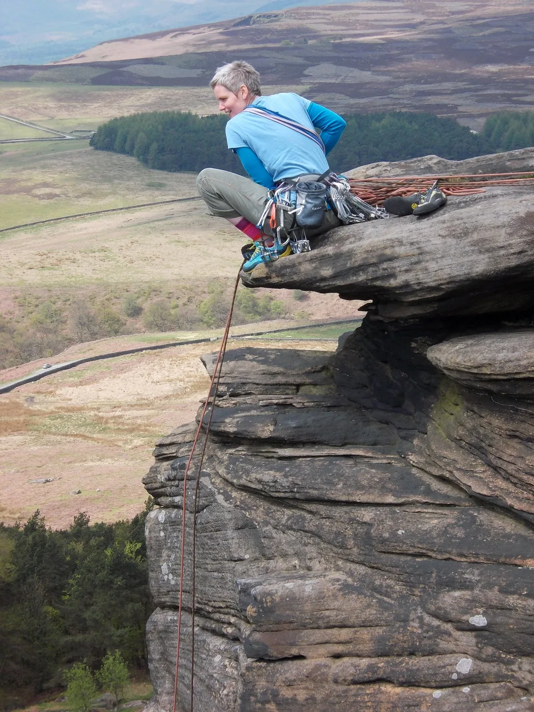 A climber on the gritstone of Stanage Edge, a short walk from Base Camp Hathersage
