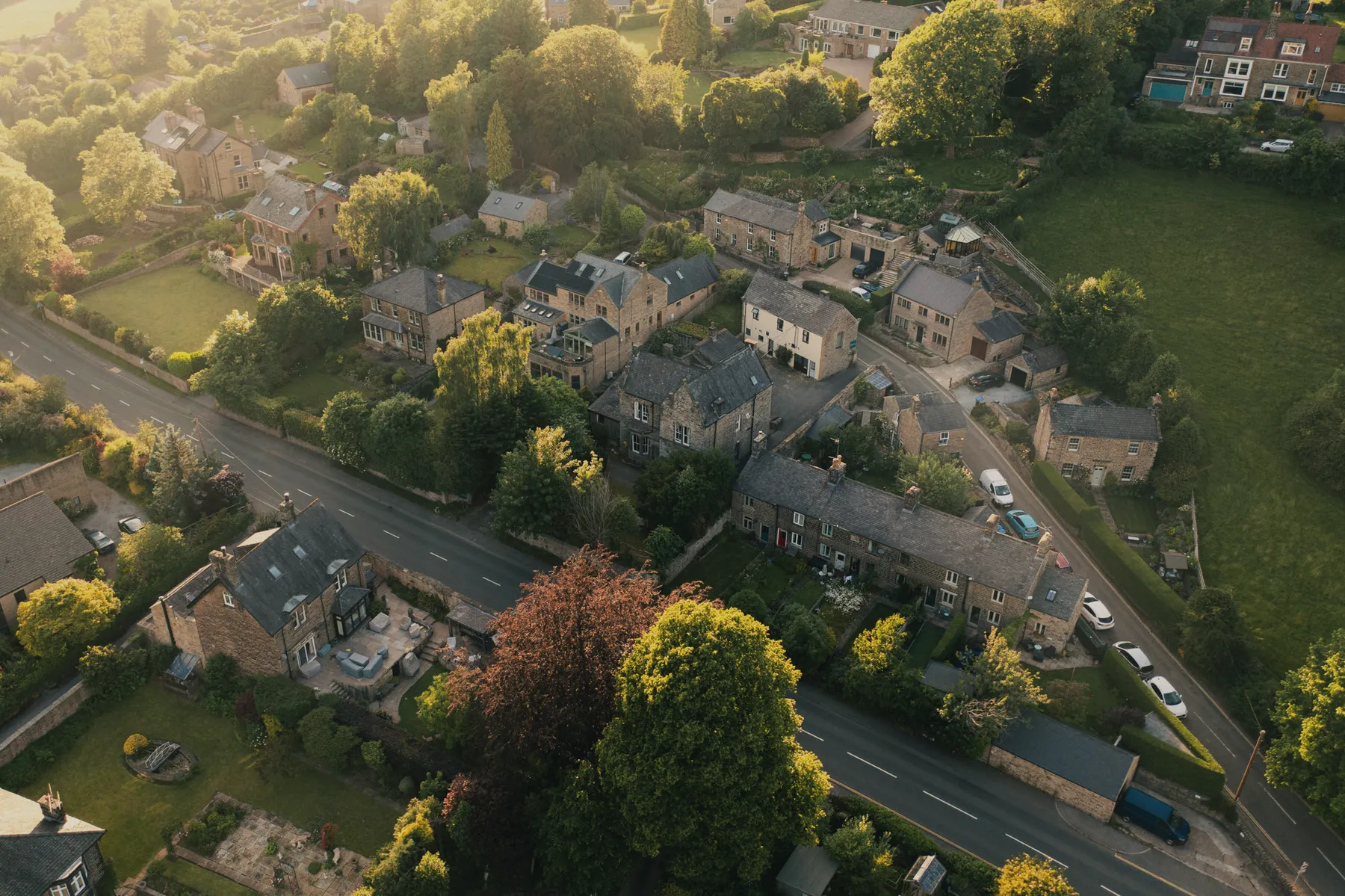 Hathersage from above: stone cottages and gardens along the Hope Valley, moorland rising behind