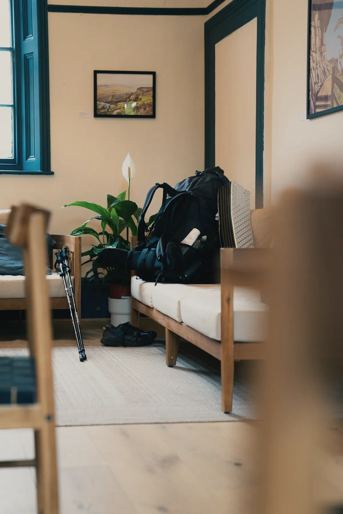 A bright private room at Base Camp Hathersage, a rucksack on the bed and the window open to the trees