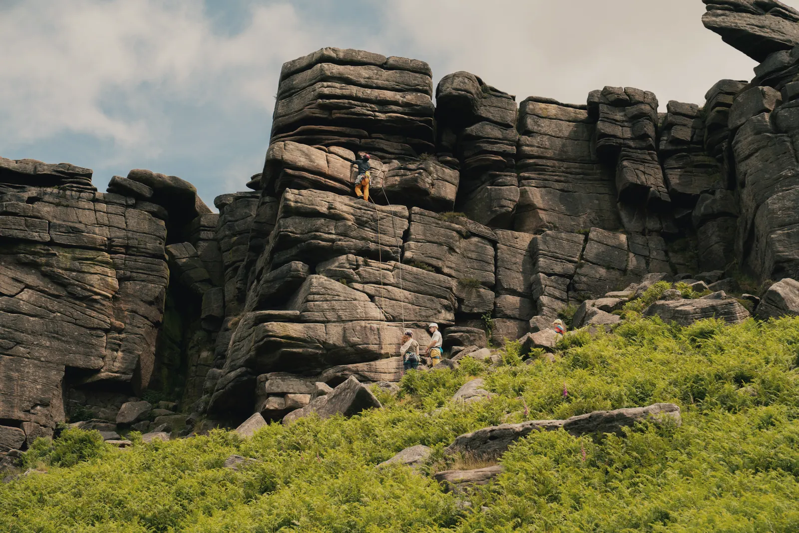 A climber on the gritstone of Stanage Edge, a short walk from Base Camp Hathersage