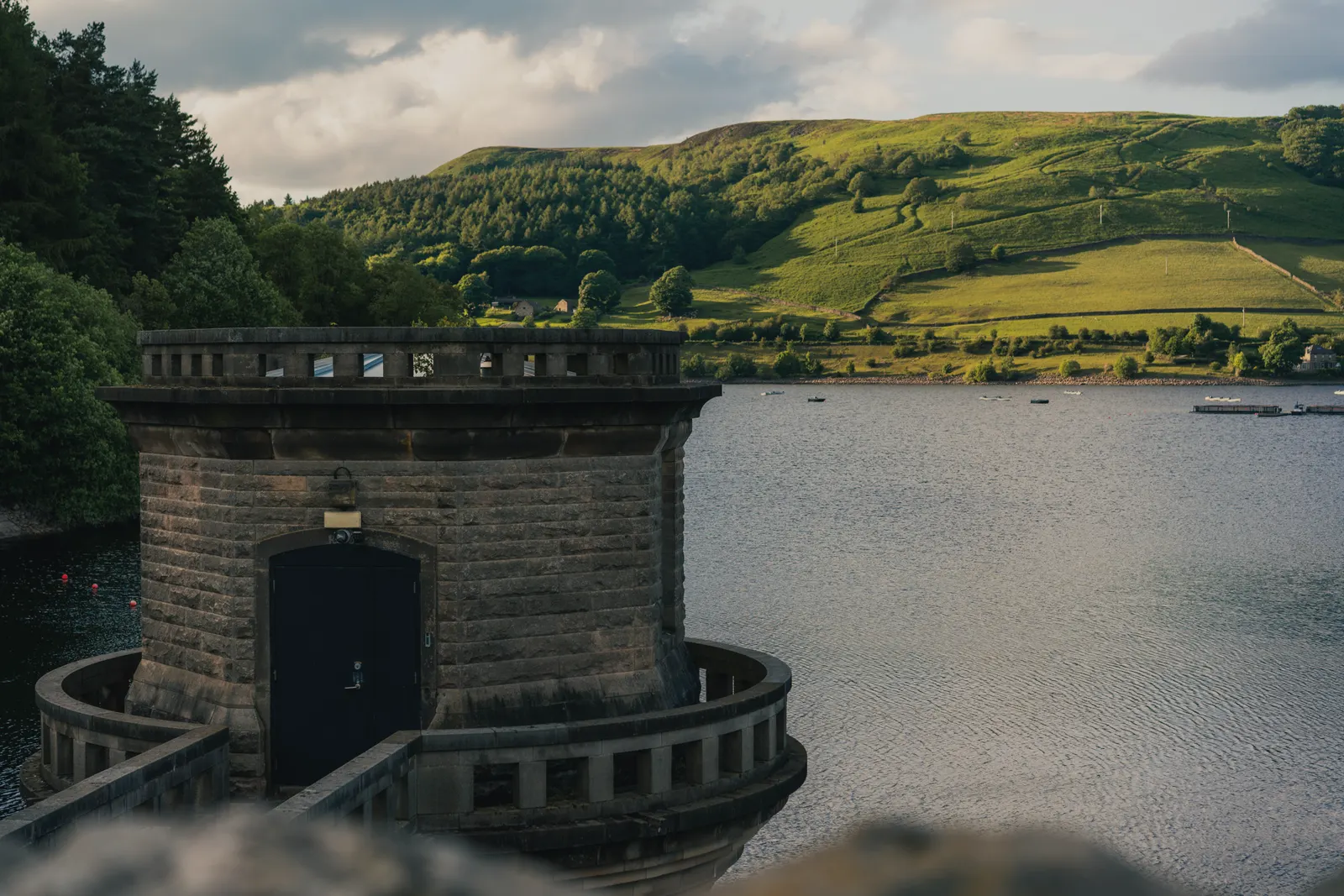 The stone tower of Derwent Dam above Ladybower Reservoir, Win Hill behind