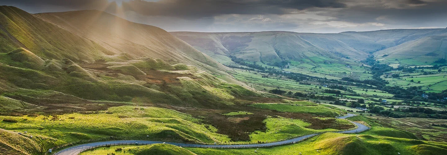 The Hope Valley winding through the Peak District below the gritstone edges